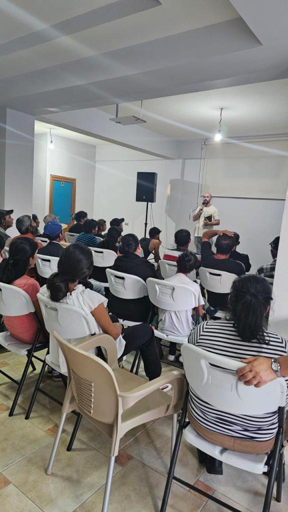 An apple painted with wine colored oil paint is next to a creamy, white painted racking of grapes in front of a clay paint...